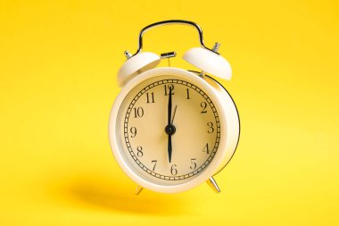 Sarı zemin üzerinde beyaz alarm saati