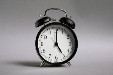 Gri arkaplanda bir siyah alarm saati
