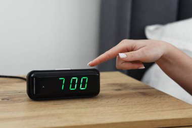 Kadın, başucundaki masanın dijital alarmını kapatıyor.