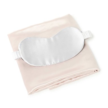 Beyaz arka planda ipek çarşaflar ve uyku maskesi.