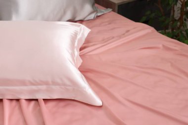 İçinde güzel ipek çarşaflar olan bir yatak, yakın plan. Metin için boşluk