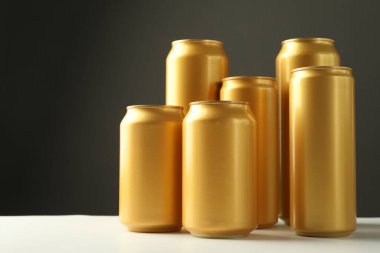 Gri arkaplana karşı beyaz masada birçok teneke kutu, metin için boşluk