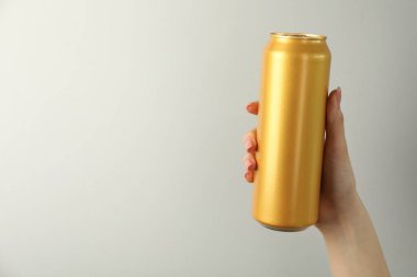 Açık gri arka planda teneke kutusu olan kadın, yakın plan. Metin için boşluk