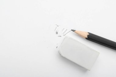 Eraser and pencil on white background, flat lay. Space for text