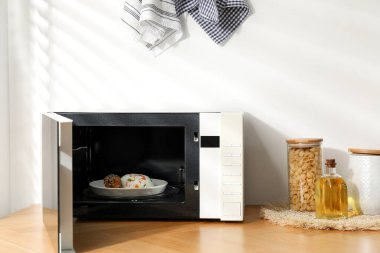 Mikrodalga fırını aç, pilav ve tavukla birlikte ahşap masa içinde.