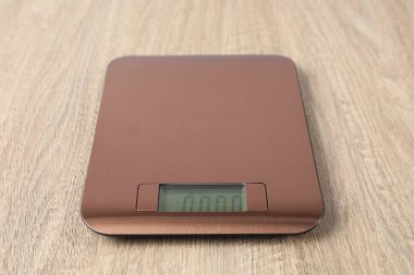 Modern elektronik mutfak terazisi ahşap masa, yakın plan.