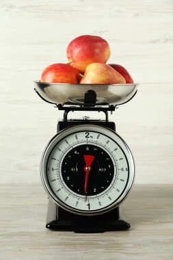 Retro mechanical kitchen scale with apples on wooden table