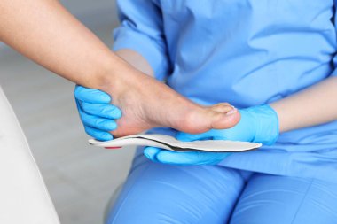 Hastanedeki hastanın ayağına taban takan doktor, yakın plan.