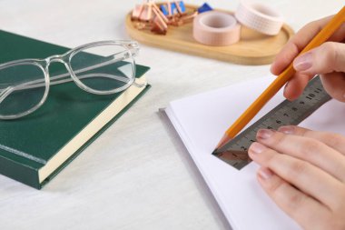 Işık masasında cetvel ve kalemle çizim yapan kadın, yakın plan.