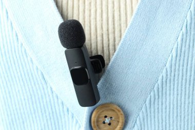 Gömleğinde lavalier mikrofon olan bir kadın, yakın plan.