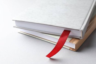 Kırmızı kurdele yer imi ve açık gri masada renkli bir kitap, yakın plan.