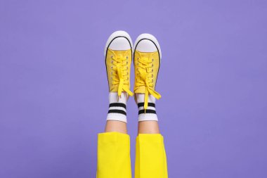 Mor arka planda şık ayakkabılar giyen kadın, yakın plan.