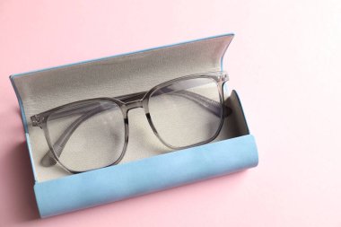 Pembe arka planda şık gözlüklü çanta, yakın plan.