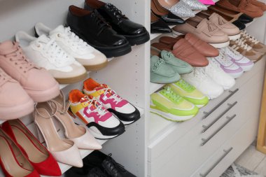 Ayakkabı deposu. Bir sürü farklı ayakkabı çifti olan raf ünitesi kapalı, yakın plan.