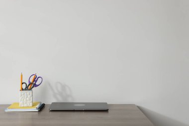 Diz üstü bilgisayar ve ahşap ofis masasında beyaz arkaplan, metin için yer