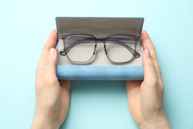 Gözlüklü kadın açık mavi arka plan, üst görünüm