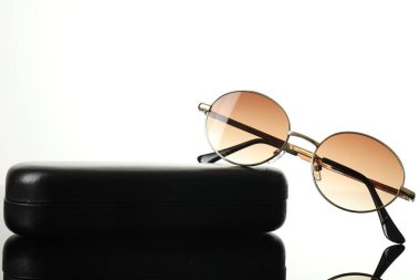 Güneş gözlüğü ve beyaz ayna yüzeyindeki çanta, yakın plan. Metin için boşluk