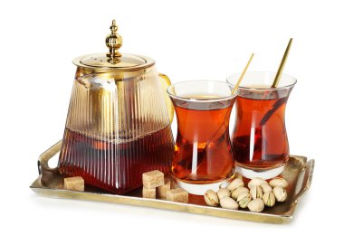 Beyaz bardakta geleneksel Türk çayı, çaydanlık, esmer şeker ve şam fıstığı