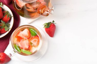 Aromatik çilekli meyve çayı ve beyaz mermer masada nane şekeri. Metin için boşluk