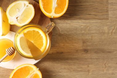 Cam fincanda Aromatik meyve çayı, portakal, limon ve bal ahşap masada, düz yatak. Metin için boşluk