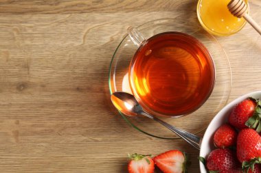 Aromatik meyve çayı, çilek ve bal, ahşap masa, düz yatak. Metin için boşluk