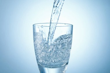 Serinletici gazoz suyunu arka plandaki cama boşaltılıyor, yakın plan.