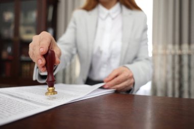 Ofisteki ahşap masada noter damgası belgesi, seçici odak