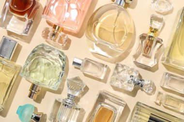 Bej arka planda çeşitli parfüm şişeleri, düzlük