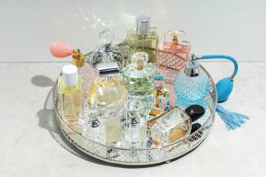 Açık dokulu masalarda farklı lüks parfümler ve aksesuarlar.