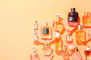 Bej arka planda farklı lüks parfümler, düz yatış. Metin için boşluk