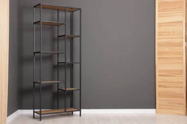 Boş raf ünitesi ve gri duvarın yanında katlanan ekran, metin için boşluk