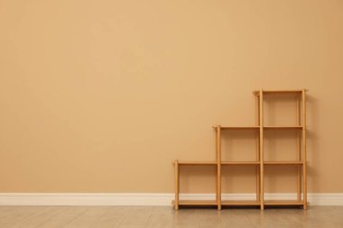 Empty shelving unit near beige wall indoors, space for text
