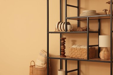 Shelving unit with decor near beige wall indoors, space for text