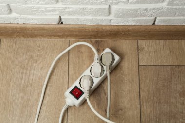 Eklenti güç panosu ahşap zemin üzerindeki prizlerle aşırı yüklenmiş, üst görünüm