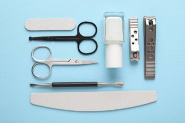 Açık mavi zemin üzerinde farklı manikür araçları kümesi, düz yatıyordu