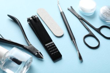 Açık mavi arkaplanda farklı manikür araçları seti, yakın plan