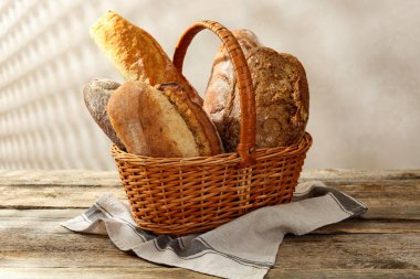 Tahta masadaki sepetin içinde farklı somunlar, yakın çekim.