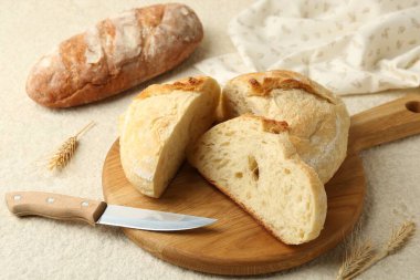 Farklı türde taze ekmek, bıçak ve dikenler açık dokulu masa, yakın plan