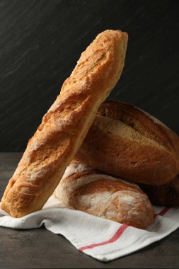 Koyu dokulu masada farklı taze ekmek türleri, yakın çekim.