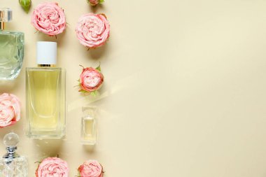Parfüm şişeleri ve bej arka planda güzel çiçekler. Metin için boşluk