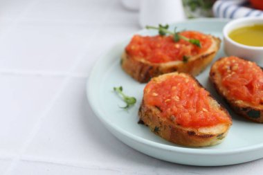 Domatesli lezzetli ekmek, mikroyeşillikler ve beyaz masada yağ, yakın plan. Metin için boşluk