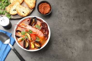 Gri dokuma masasında servis edilen lezzetli deniz ürünleri çorbası. Metin için boşluk