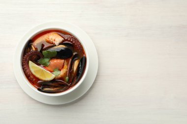 Hafif ahşap masada, tabakta nefis deniz ürünleri çorbası, üst manzara. Metin için boşluk