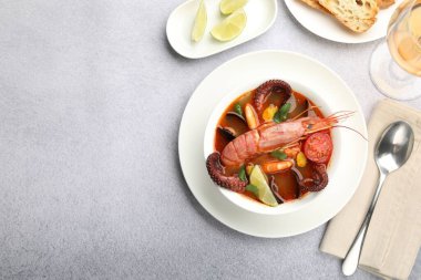 Açık gri masada servis edilen lezzetli deniz ürünleri çorbası. Metin için boşluk