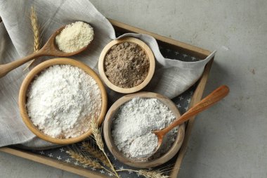 Açık gri masa üzerinde farklı un türleri, üst görünüm