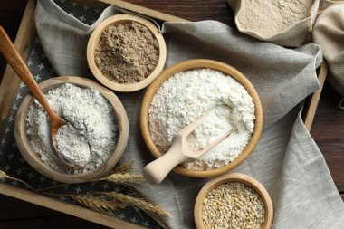 Tahta masadaki kaselerdeki farklı un türleri, düz uzanmış.