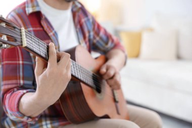 Evde gitar çalan adam, eline odaklan. Metin için boşluk