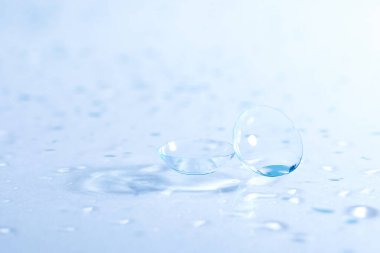 Ayna yüzeyine bir çift kontak lens ve su damlası, yakın plan.