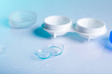 Ayna yüzeyinde kontakt lens ve konteynır, yakın plan.