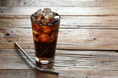 Kola, buzlu cam küplerle tazeleniyor ve ahşap masa üzerinde saman, yakın plan. Metin için boşluk